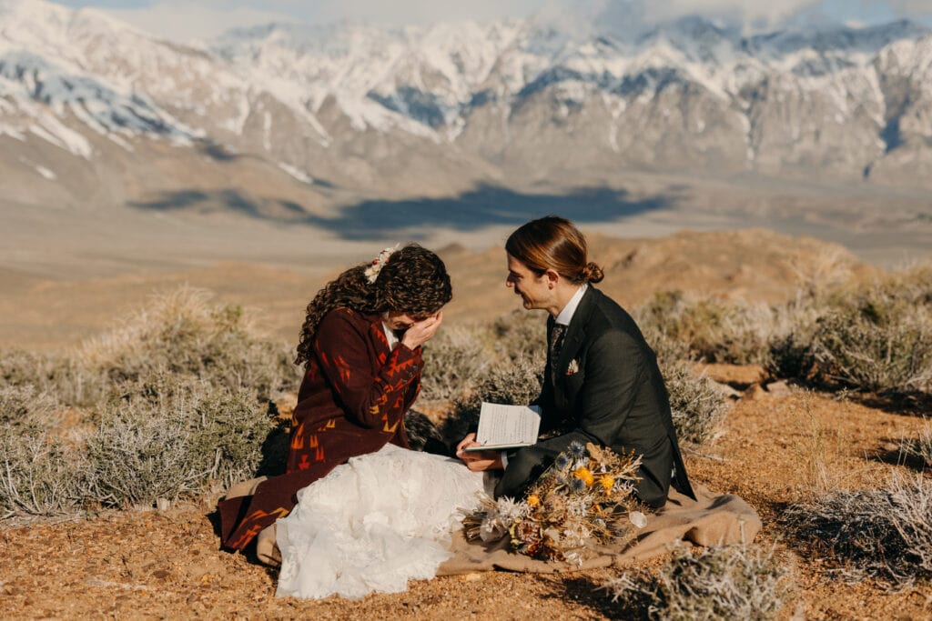The bride cries as the groom reads his vows to her.