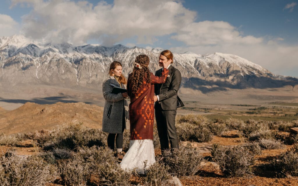 The bride wipes a tear away from the grooms face during the ceremony.