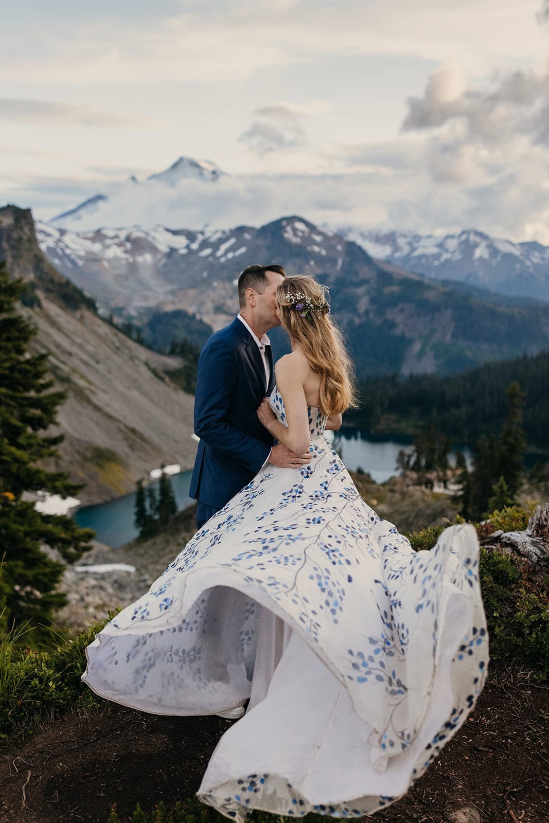 A brides dress flows around her as she gives her groom a kiss.