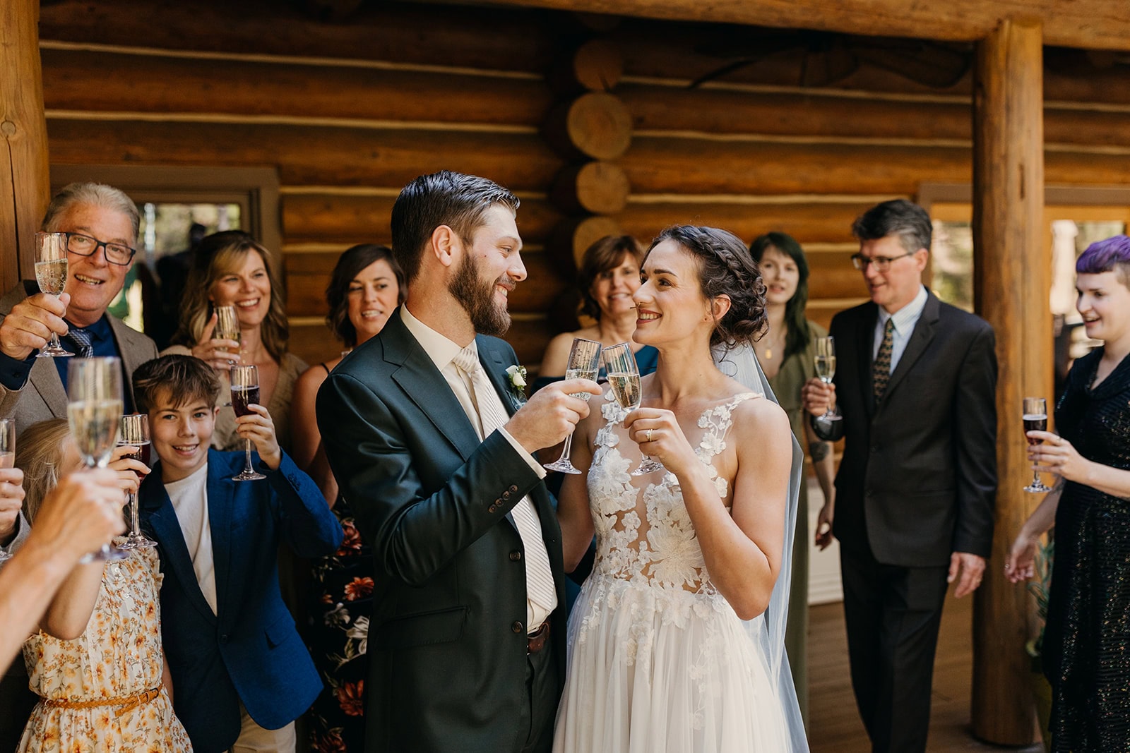 A bride and groom cheers a toast with loved ones around them