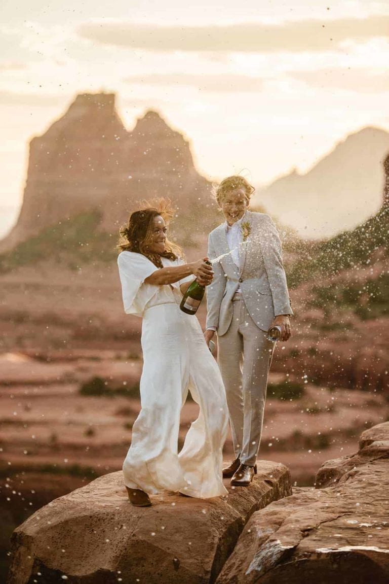 A bride sprays a bottle of Champagne at susnet.