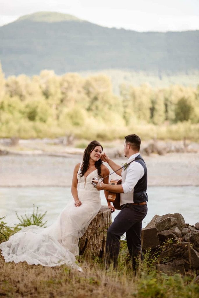A groom wipes a tear away from a bride.