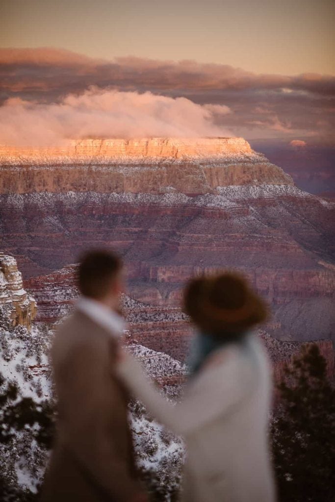 A couple stands together inside of a colorful rock formation. 