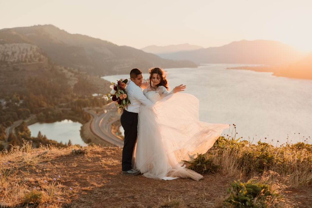 A bride tosses her dress in the sunlight.