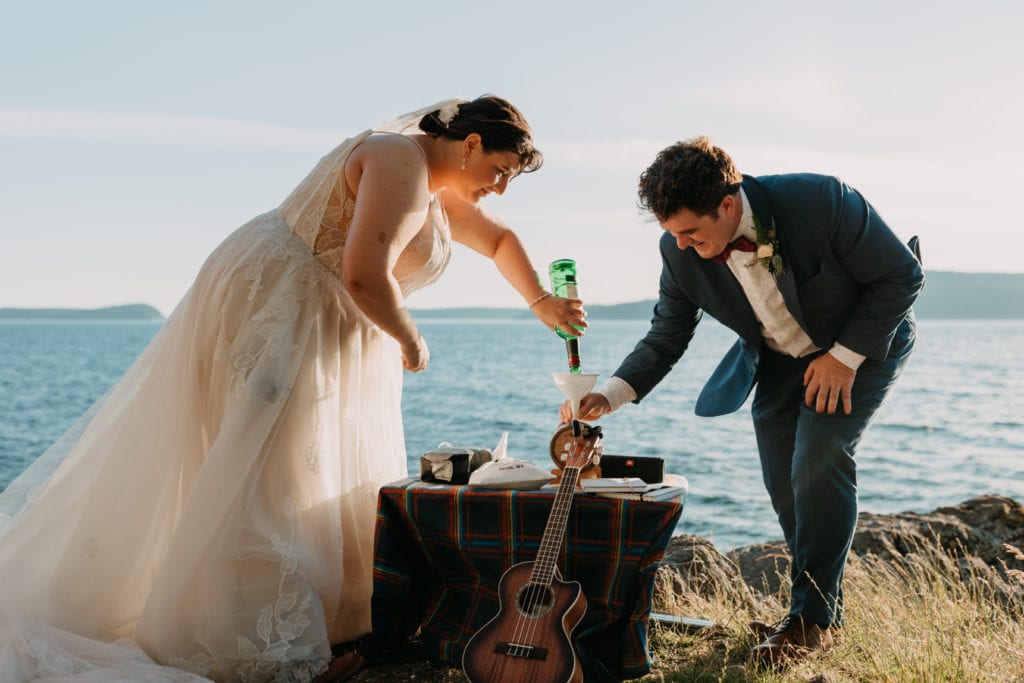 A bride and groom make a cocktail together.