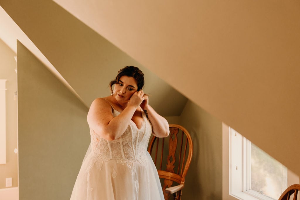 A bride putting on her earrings