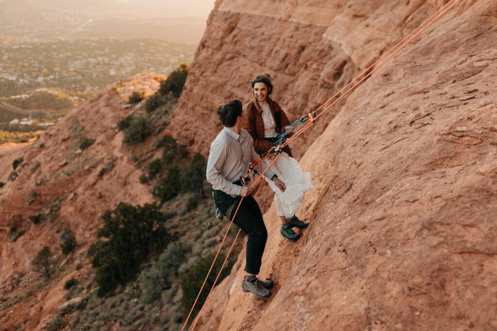 A bride and groom rappel together down a route they just climbed in Sedona