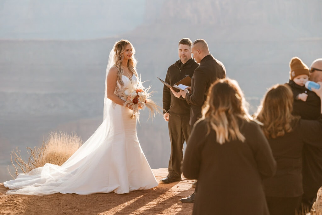 The bride smiles as she listens to the grooms vows.