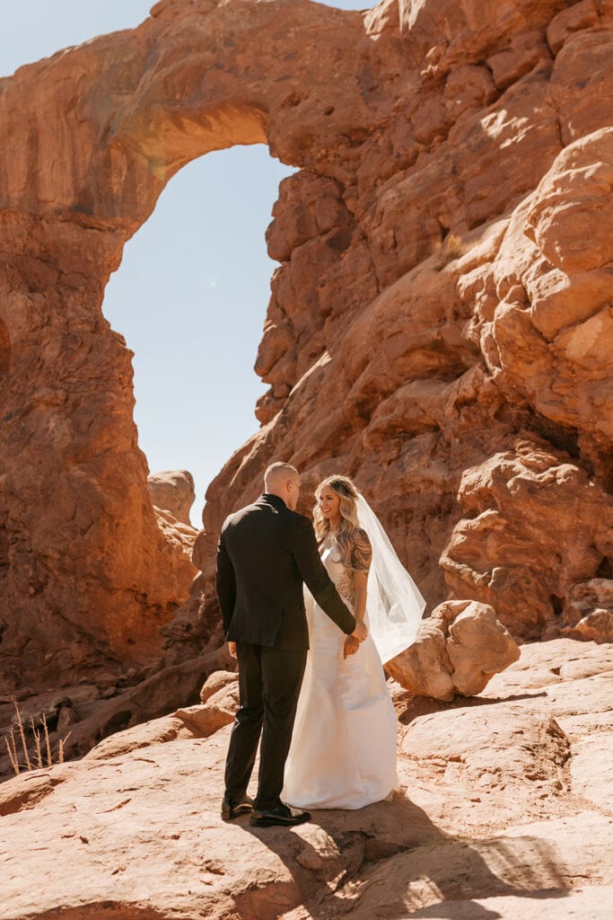 The bride smiles and admires her groom.