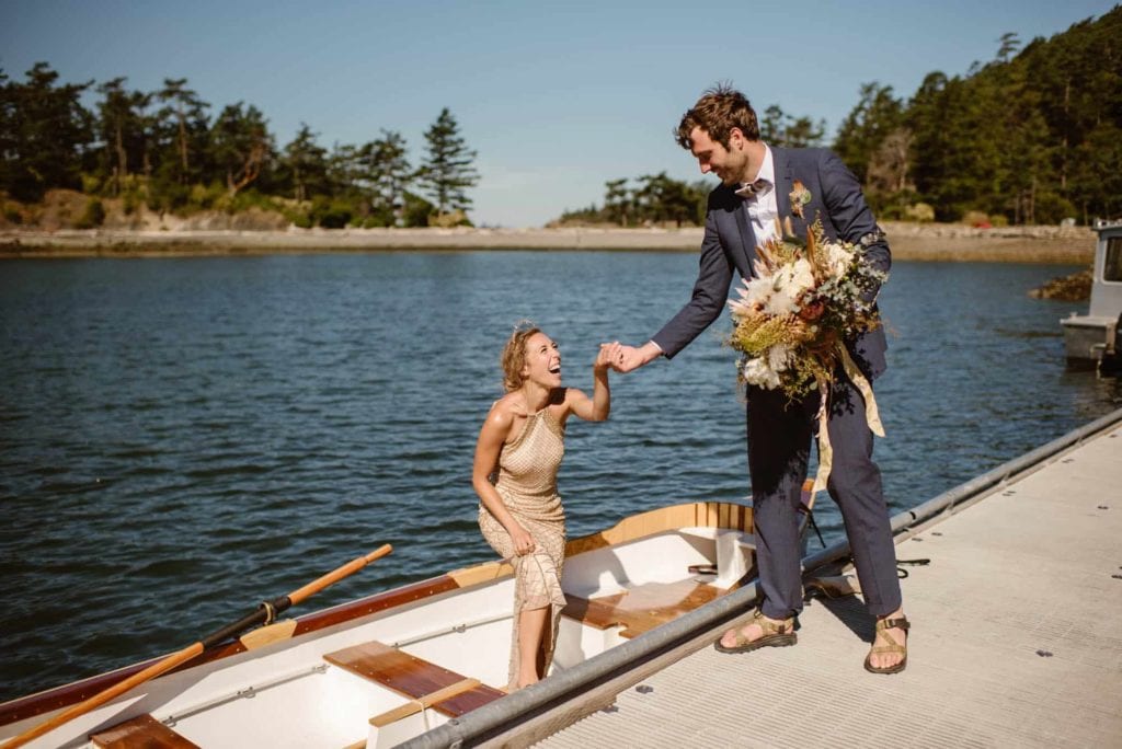 A bride smiles as she exits a boat her and her husband made together to transport them to their elopement.