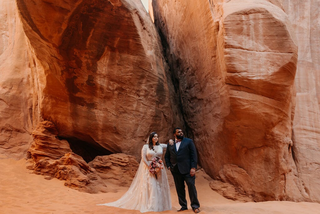 The couple stands for a serious portrait together.