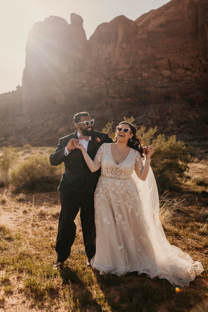 The couple takes a fun photo with heart shaped glasses on.