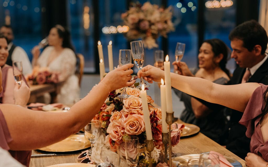 Guests of the wedding clink their glasses after a toast.
