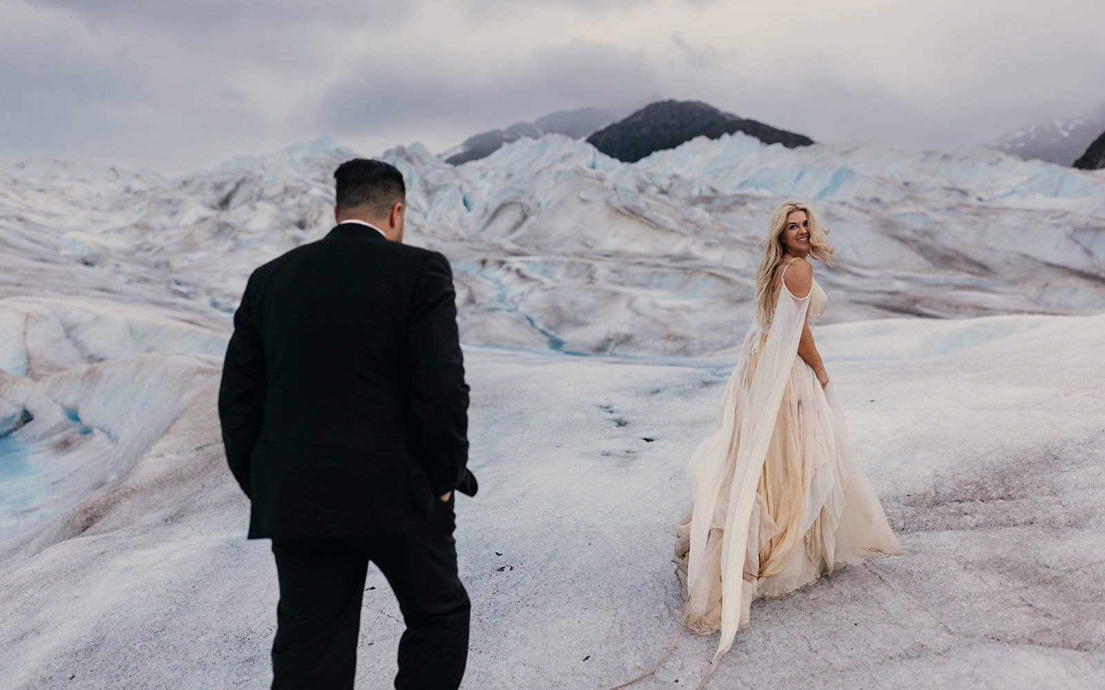 A bride wears a gorgeous wedding gown on a glacier in Alaska.