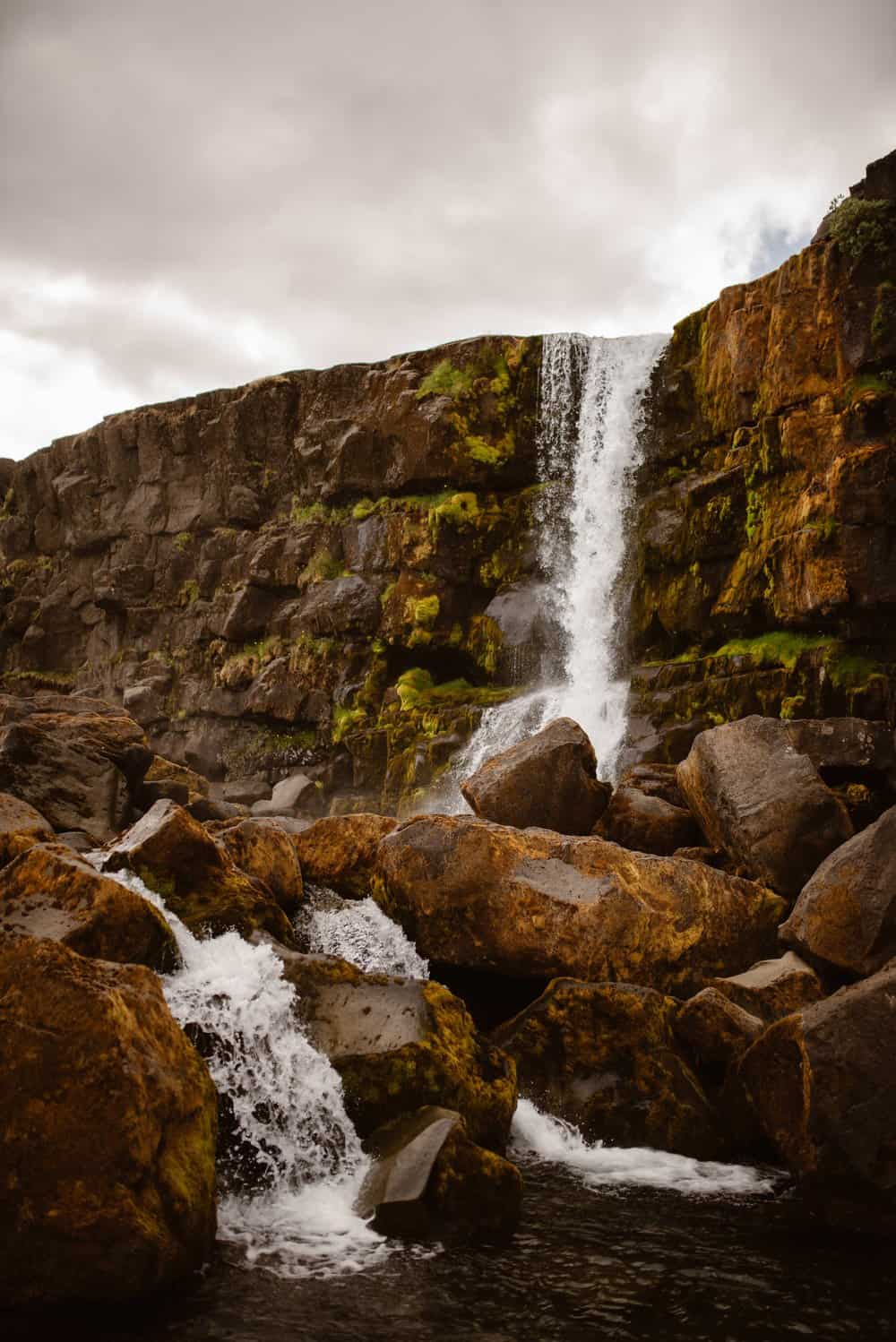 An icelandic waterfall going over rocks.