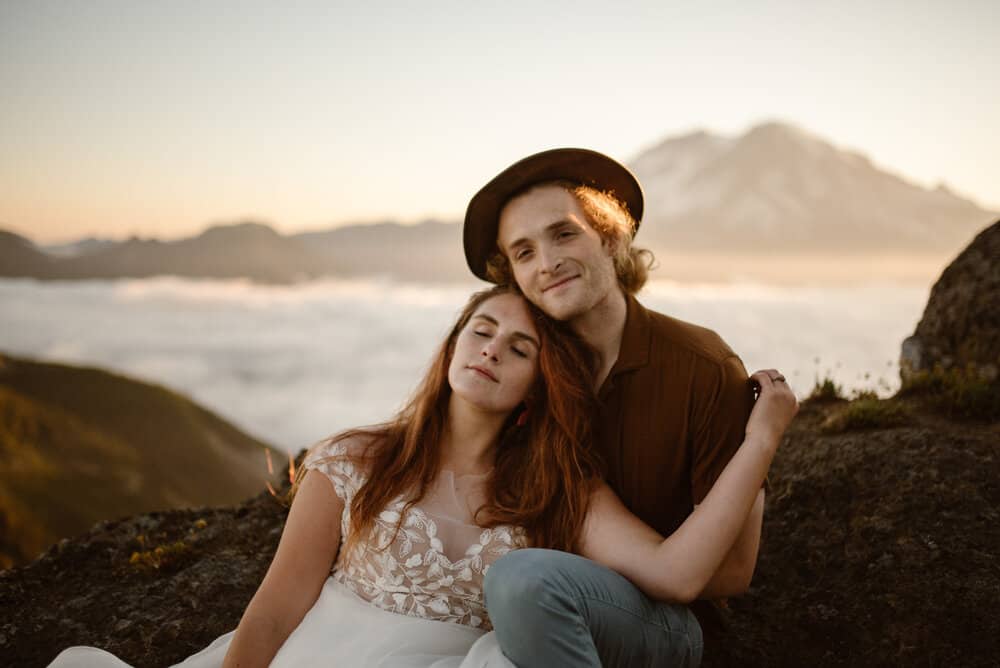 A couple sits together at sunrise at high rock lookout. 
