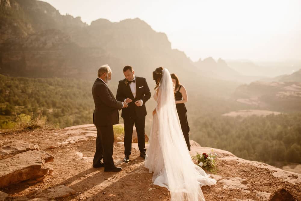 A groom takes his wedding band from his father during the ceremony.