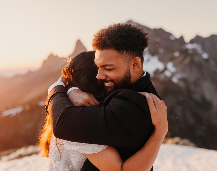 A person hugging their partner on their wedding day in the mountains