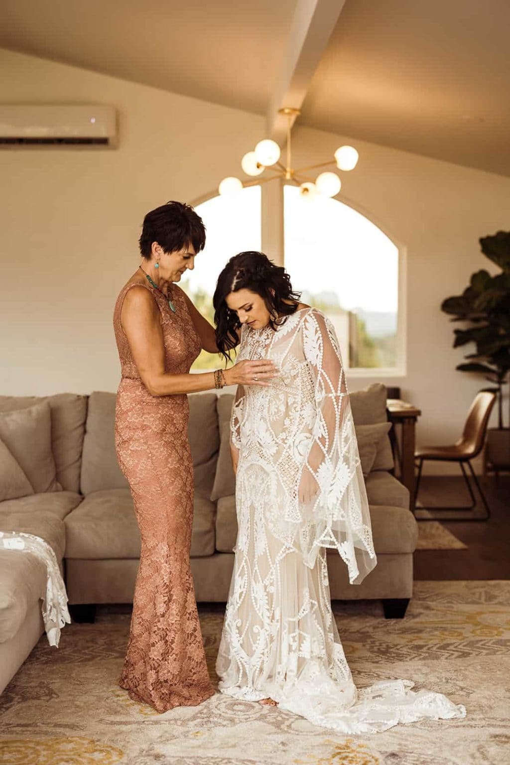 A mother helping her daughter into her wedding dress in a rental in Sedona