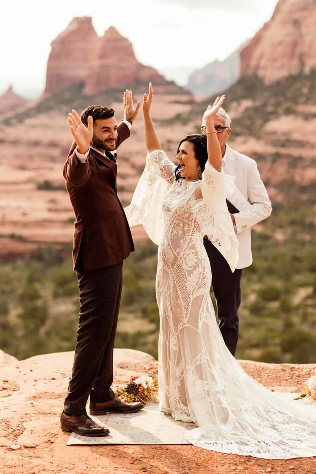 The bride and groom put their hands up in celebration as they are announced husband and wife.