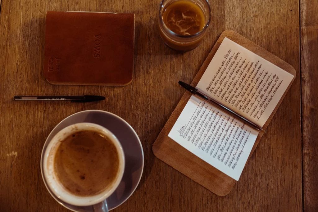 A flat lay of wedding vows and coffee