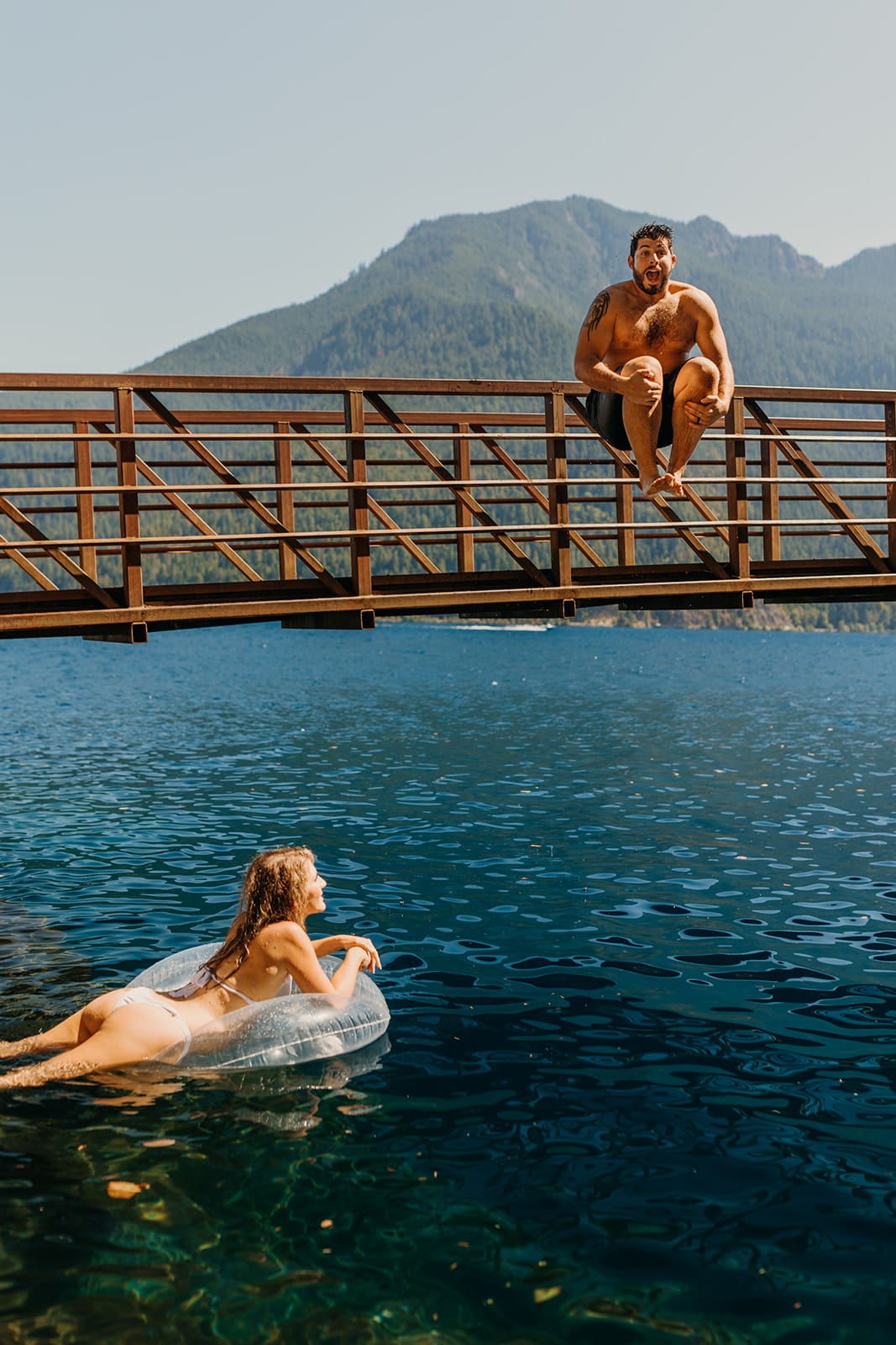 A couple plays in Lake Crescent on their elopement day.
