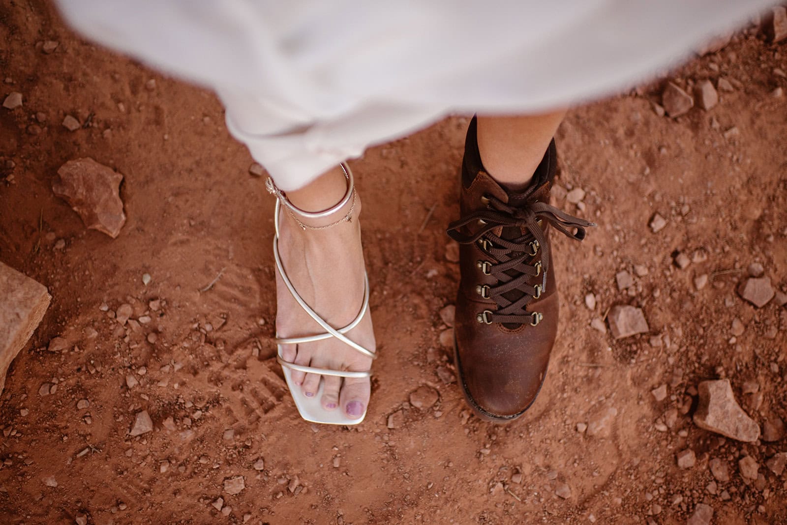 A detail photo of an adventure elopement bride's fancy ceremony heel and her hiking boots.