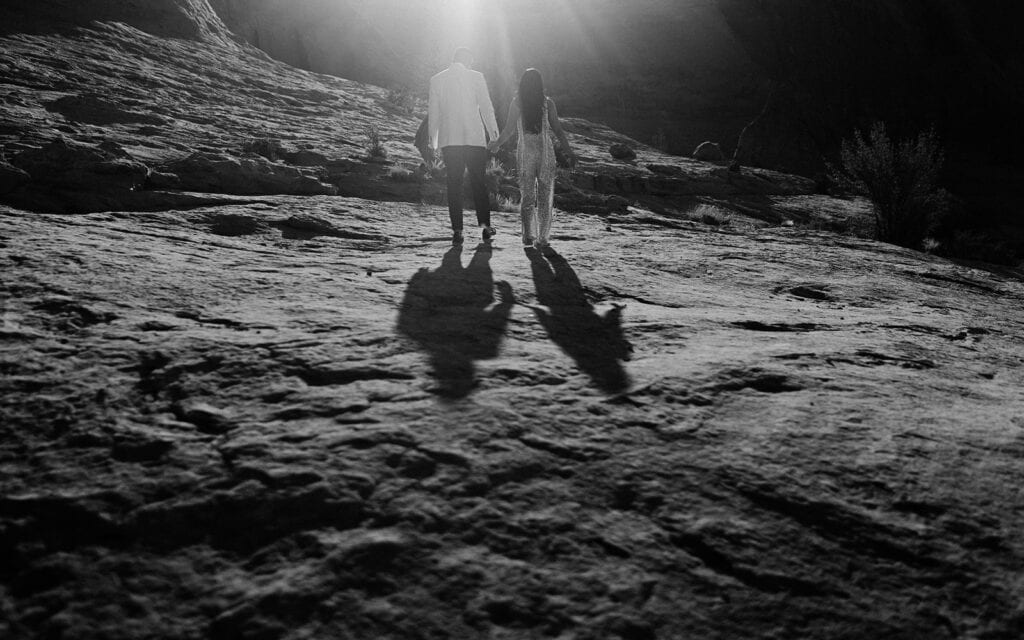 The couple walks away from the camera as the morning light casts their shadows.
