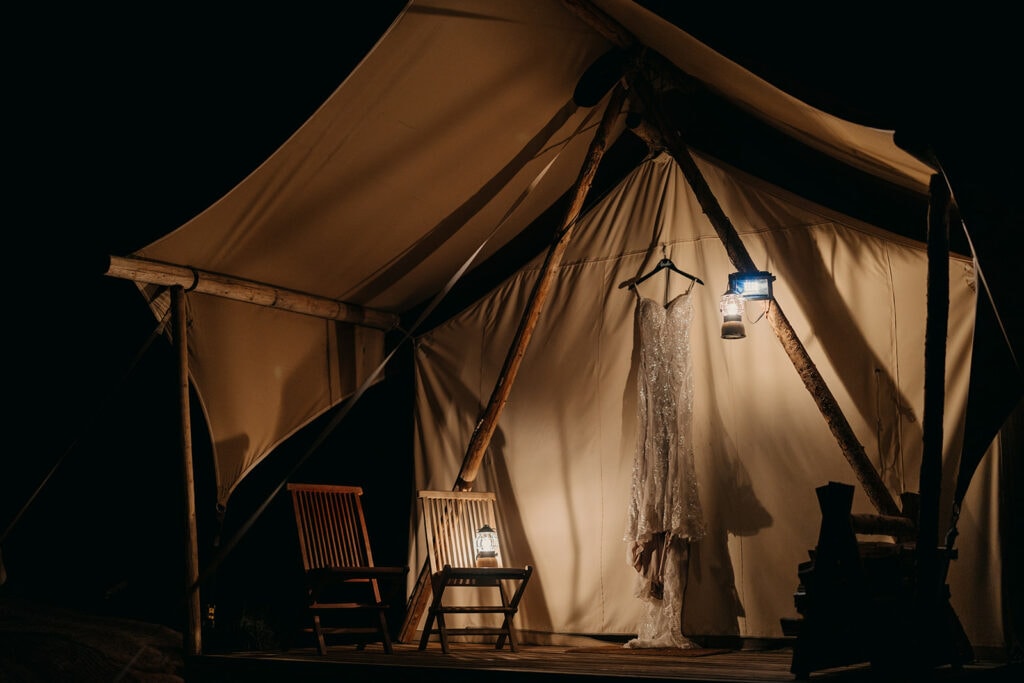 A detail photo of the wedding dress hanging outside of the Canvas Tent.