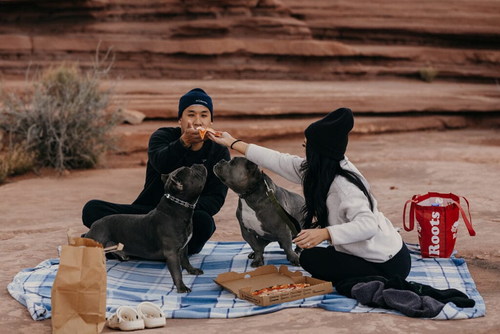 The couple shares pizza at a picnic.