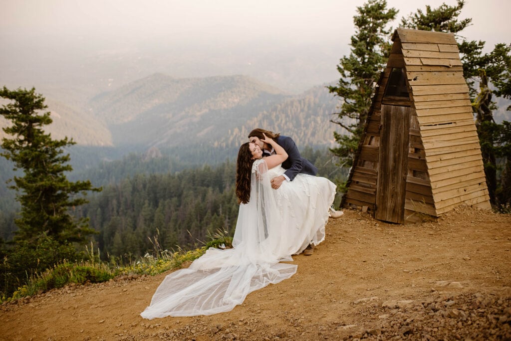 A bride and groom share a passionate kiss on a trail outside of Leavenworth, WA