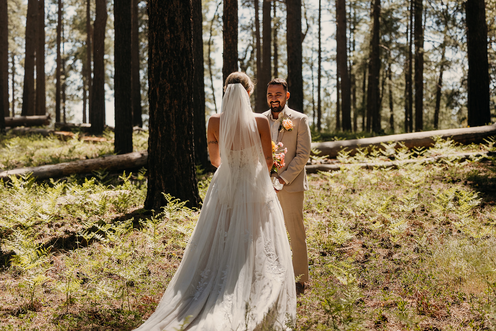 A bride and groom smile at each other before getting married.