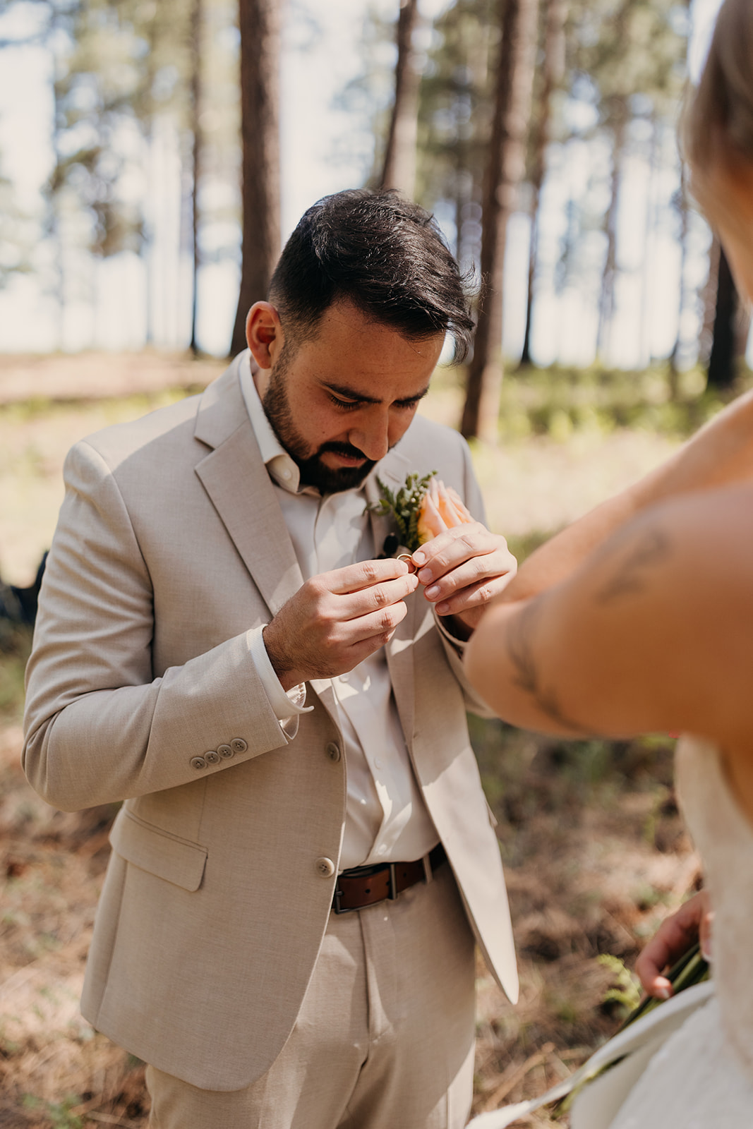 A groom admires his ring after getting married.