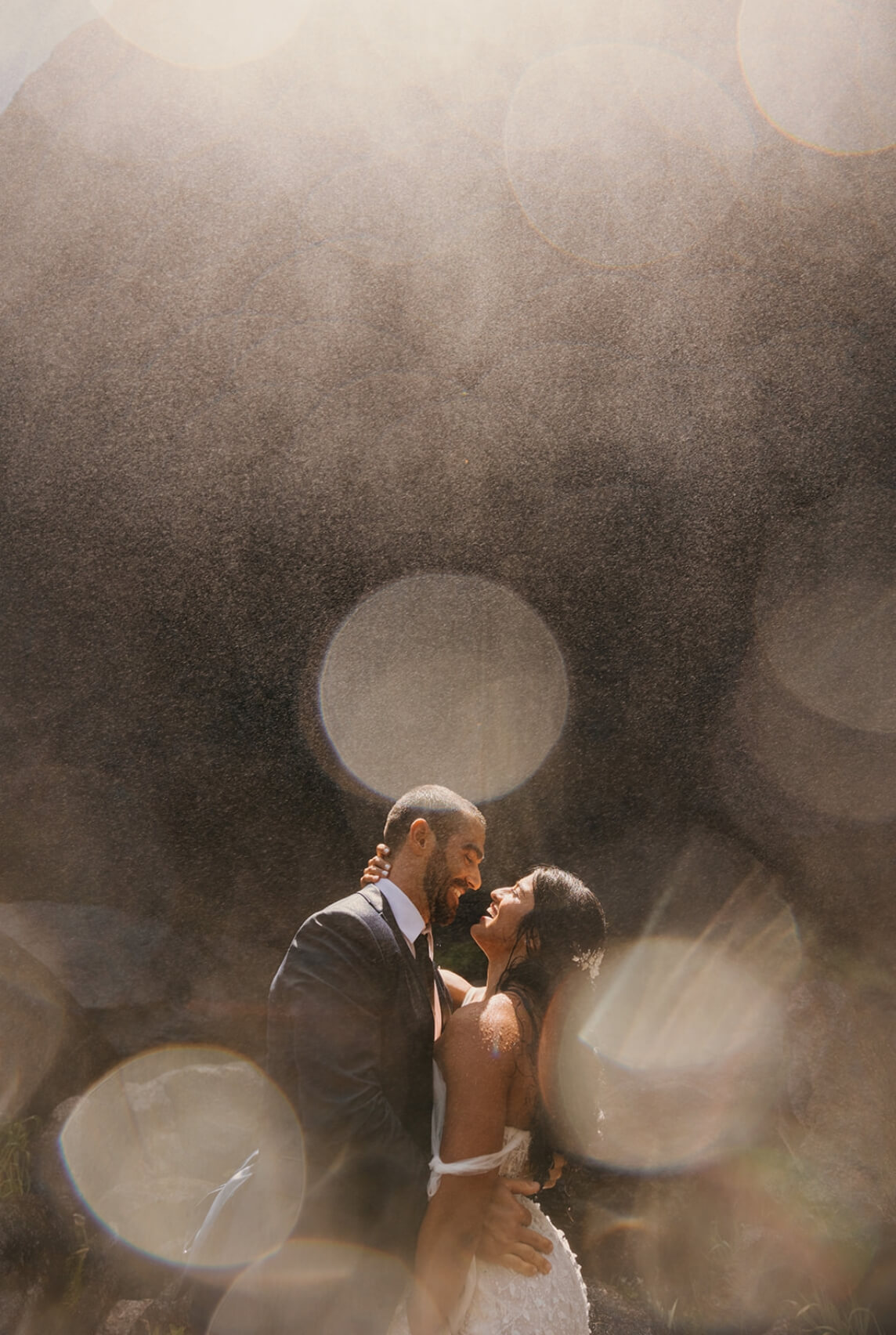 A newlywed couple standing close together about to kiss