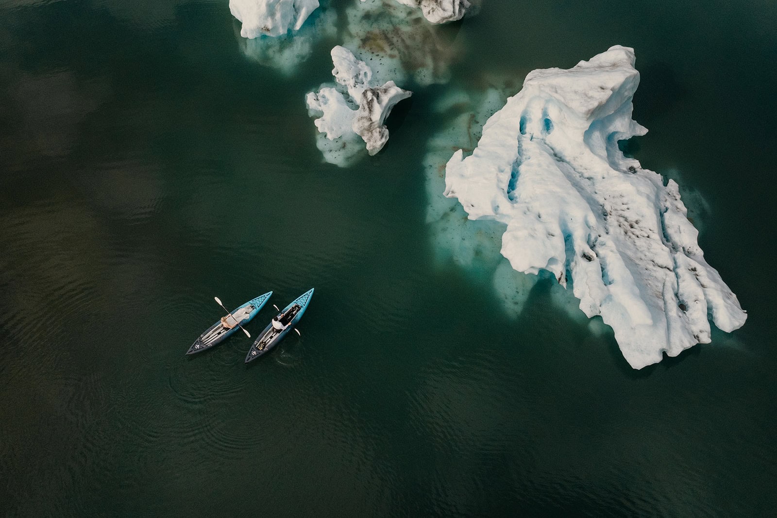 A couple kayaks around glaciers in Alaska on their elopement adventure.