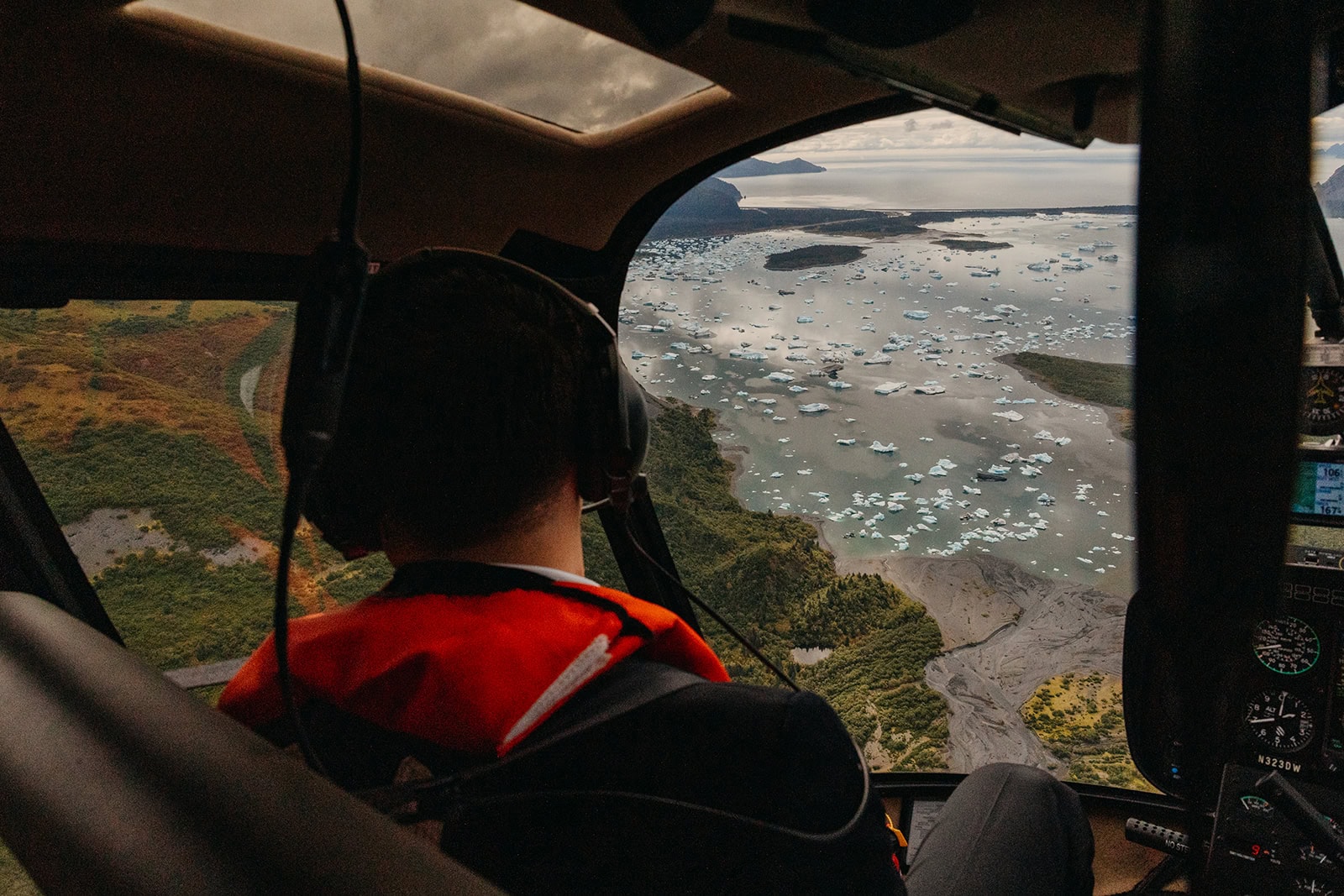 A groom looks at the view out of the helicopter window as it lands on the coast.