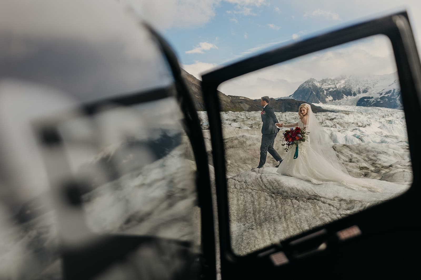 A couple walks across a glacier in Alaska after arriving via helicopter.