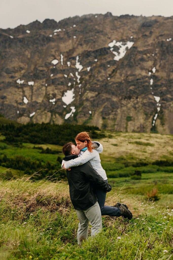 The groom picks up the bride for a kiss.