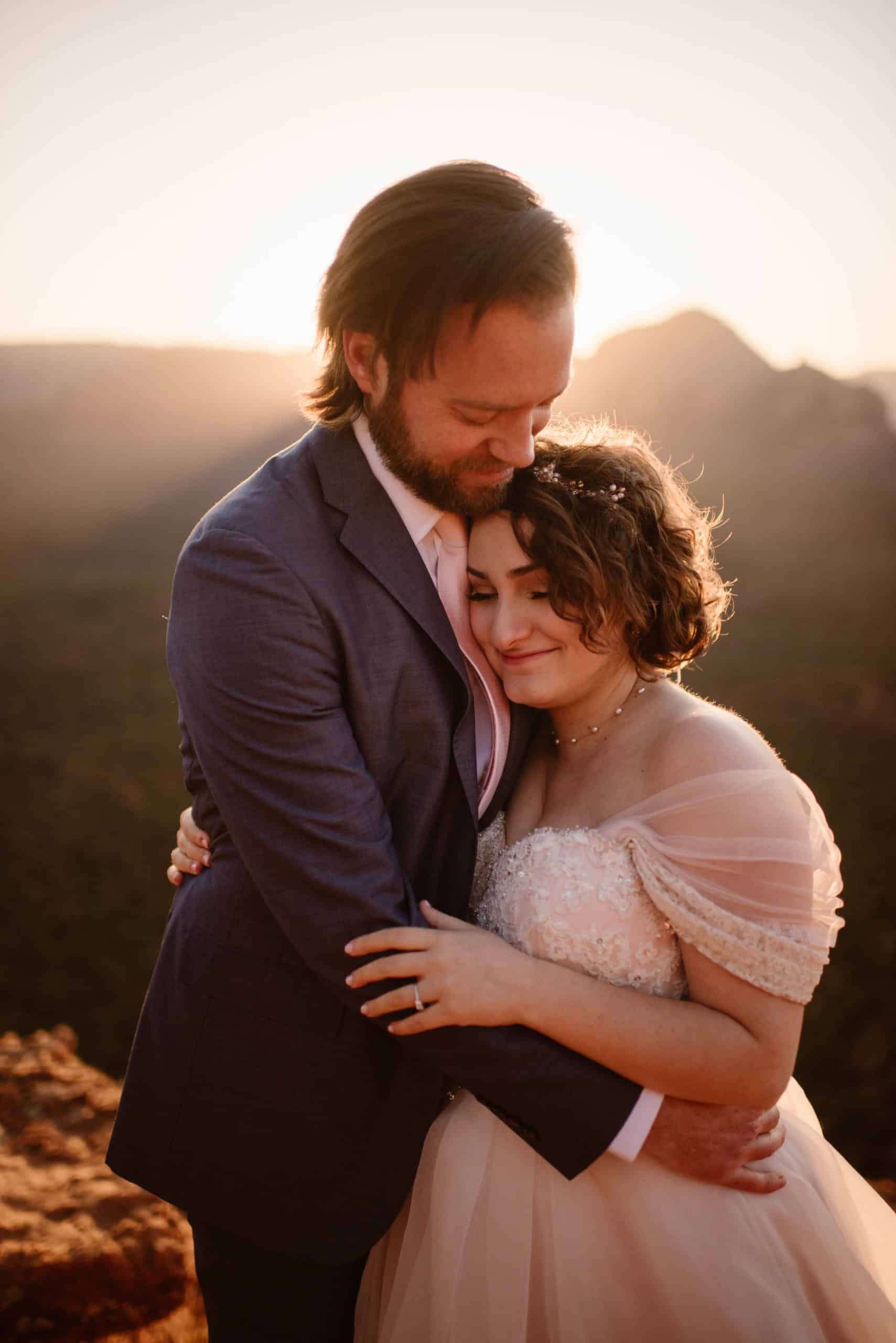A bride and groom hold each other in Sedona at surnise