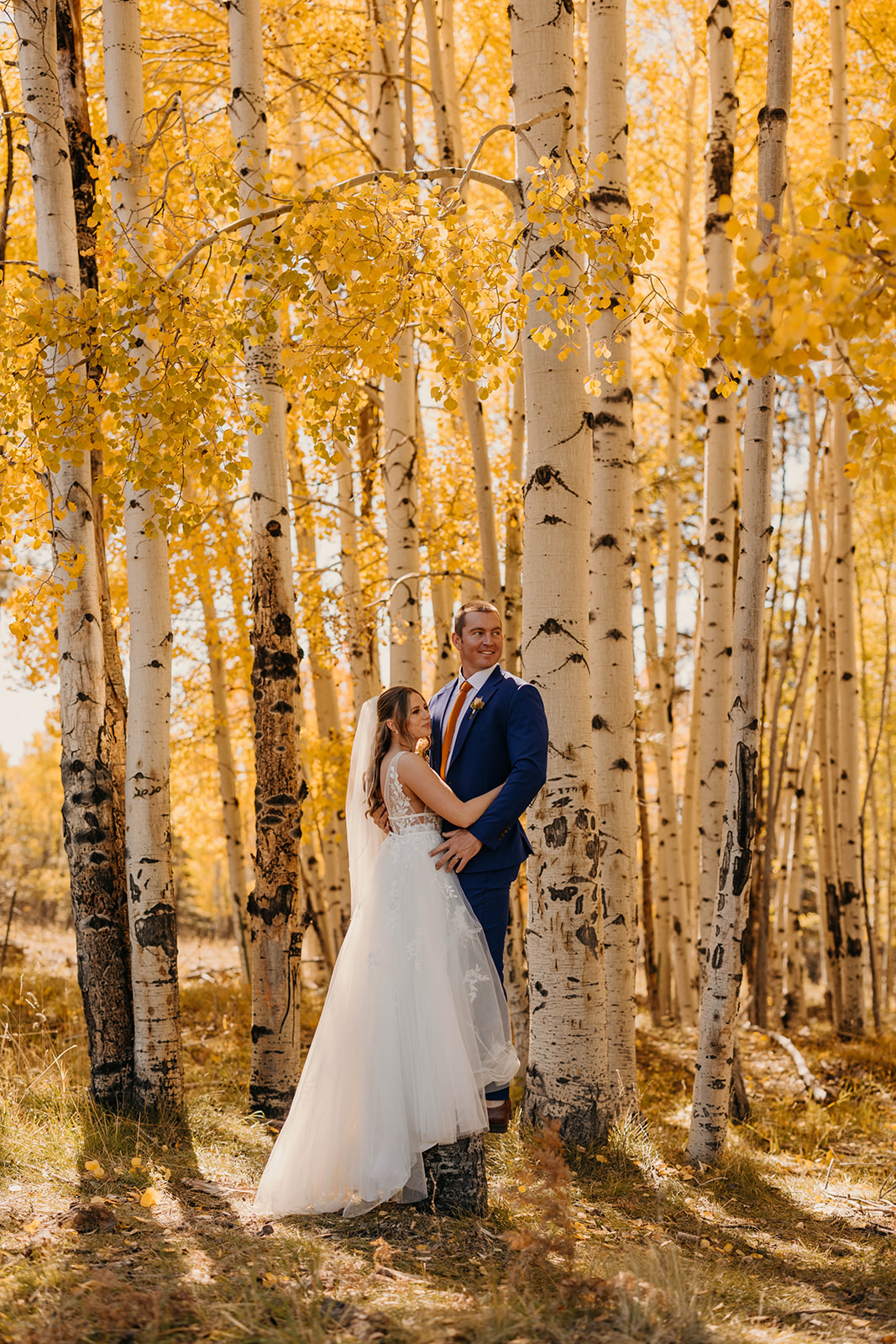 A couple stands for a portrait together on a fall day in Flagstaff, Arizona.