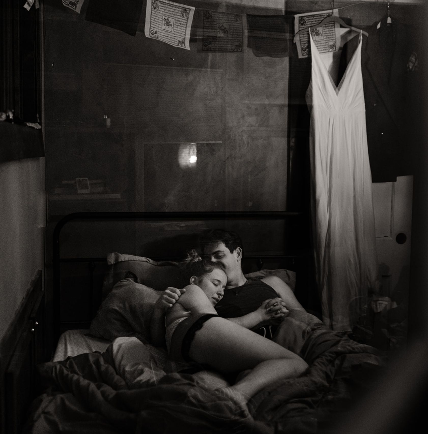 A couple curled up into each other in a bed