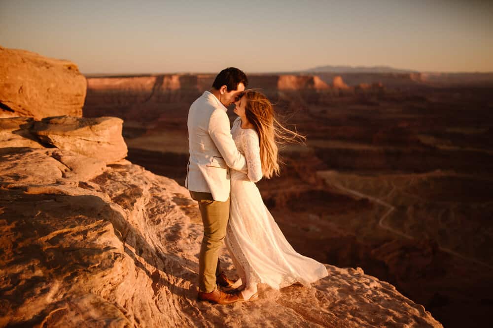 A man holds a woman close as the wind sweeps her hair.