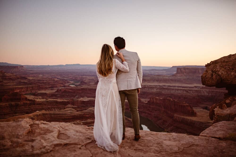 A man and woman stare out at the sunset at Dead Horse State Park.