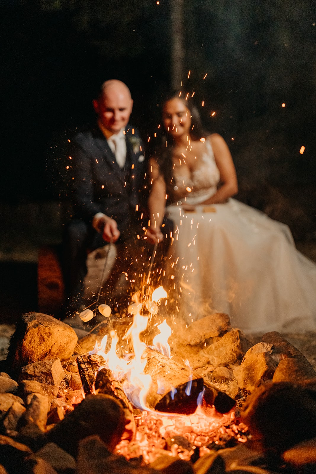 The couple roasts marshmallows by fire.