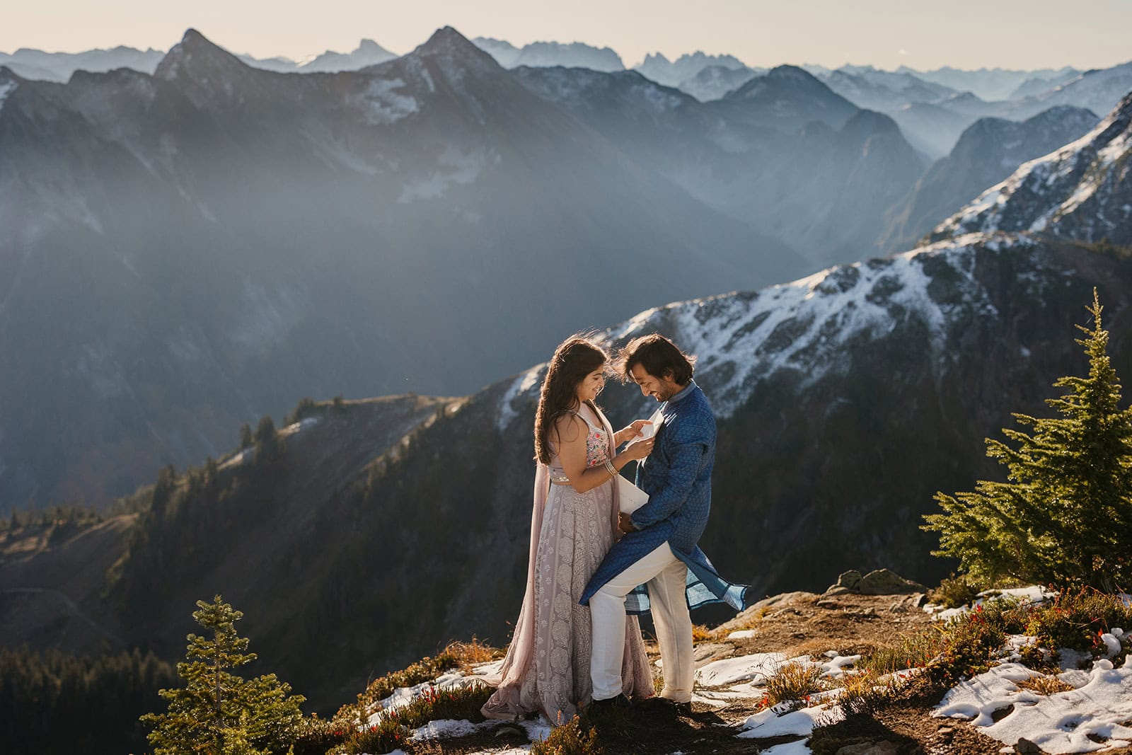 A bride reads her vows to her groom on the top of a mountain. 
