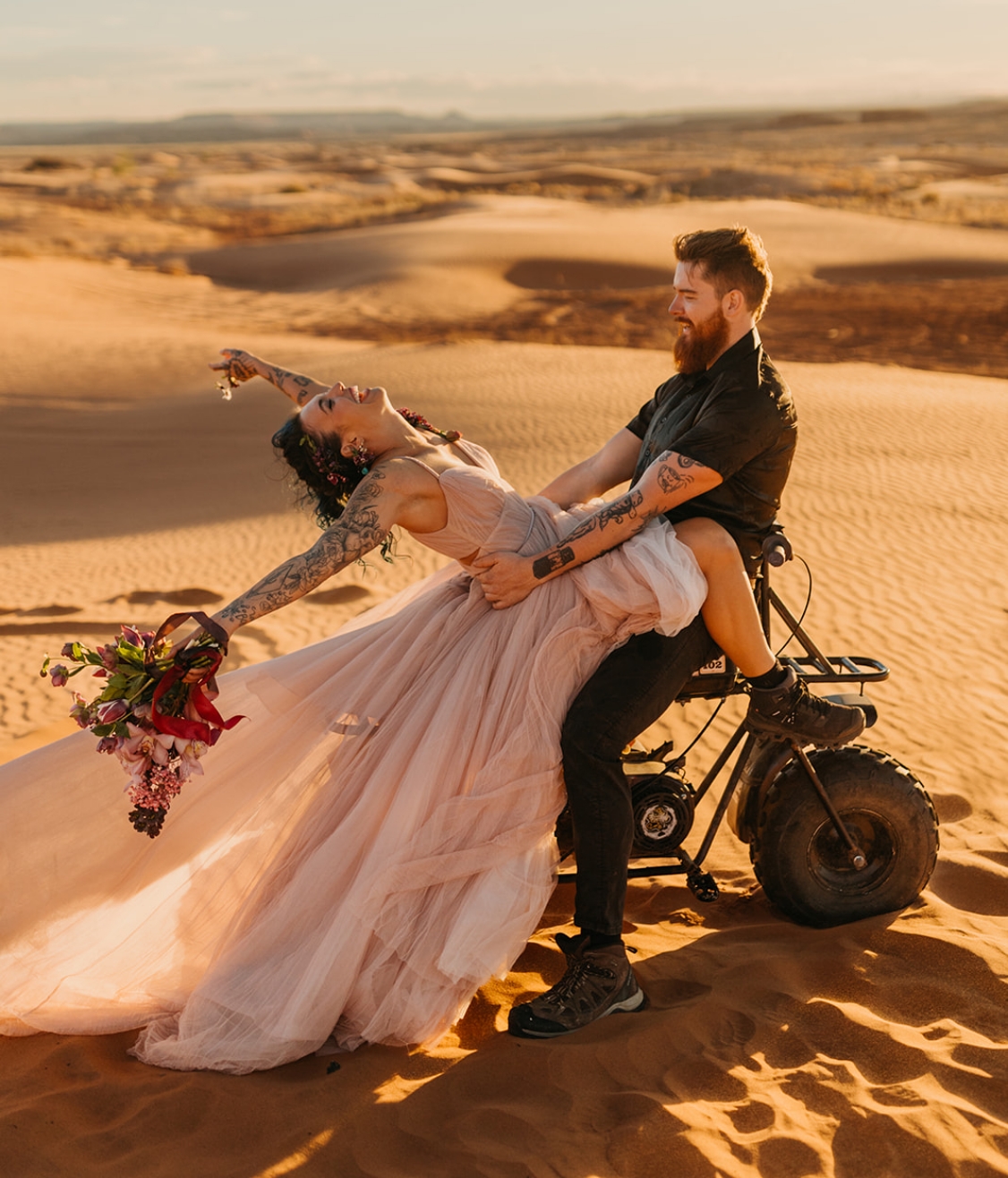 A couple has fun on their elopement day surrounded by sand.