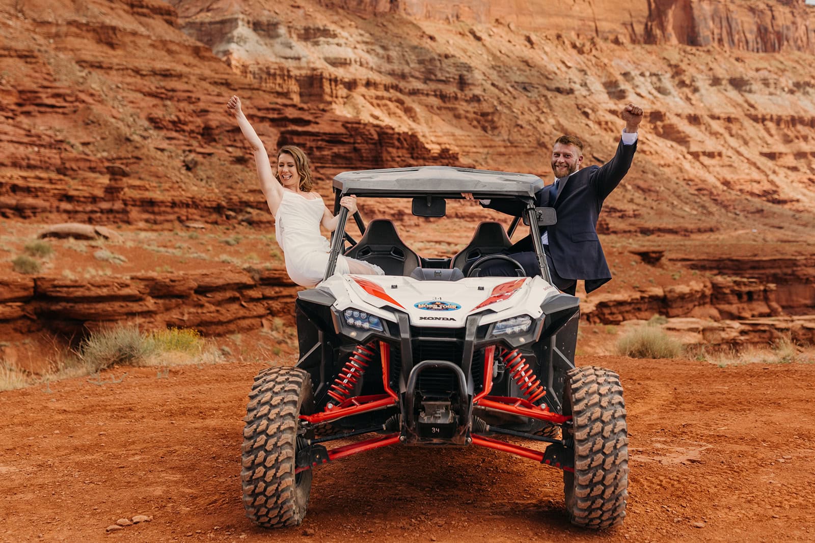 A couple poses for a photo in their rented ATV in Moab, Utah.