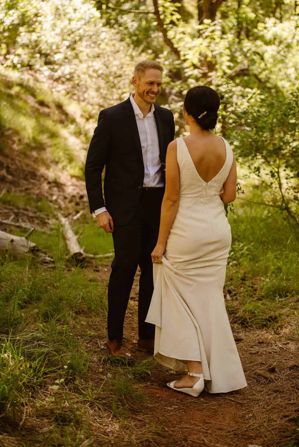 The groom smiles at the bride as he sees her for the first time in her dress. 