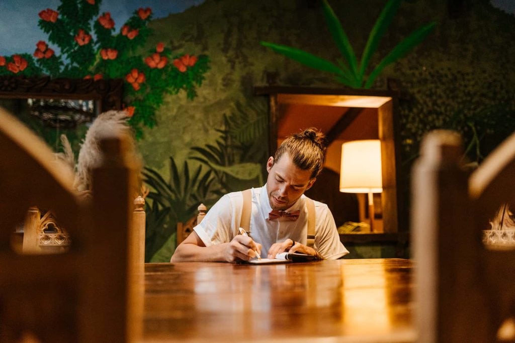 The groom writes his vows at the table.