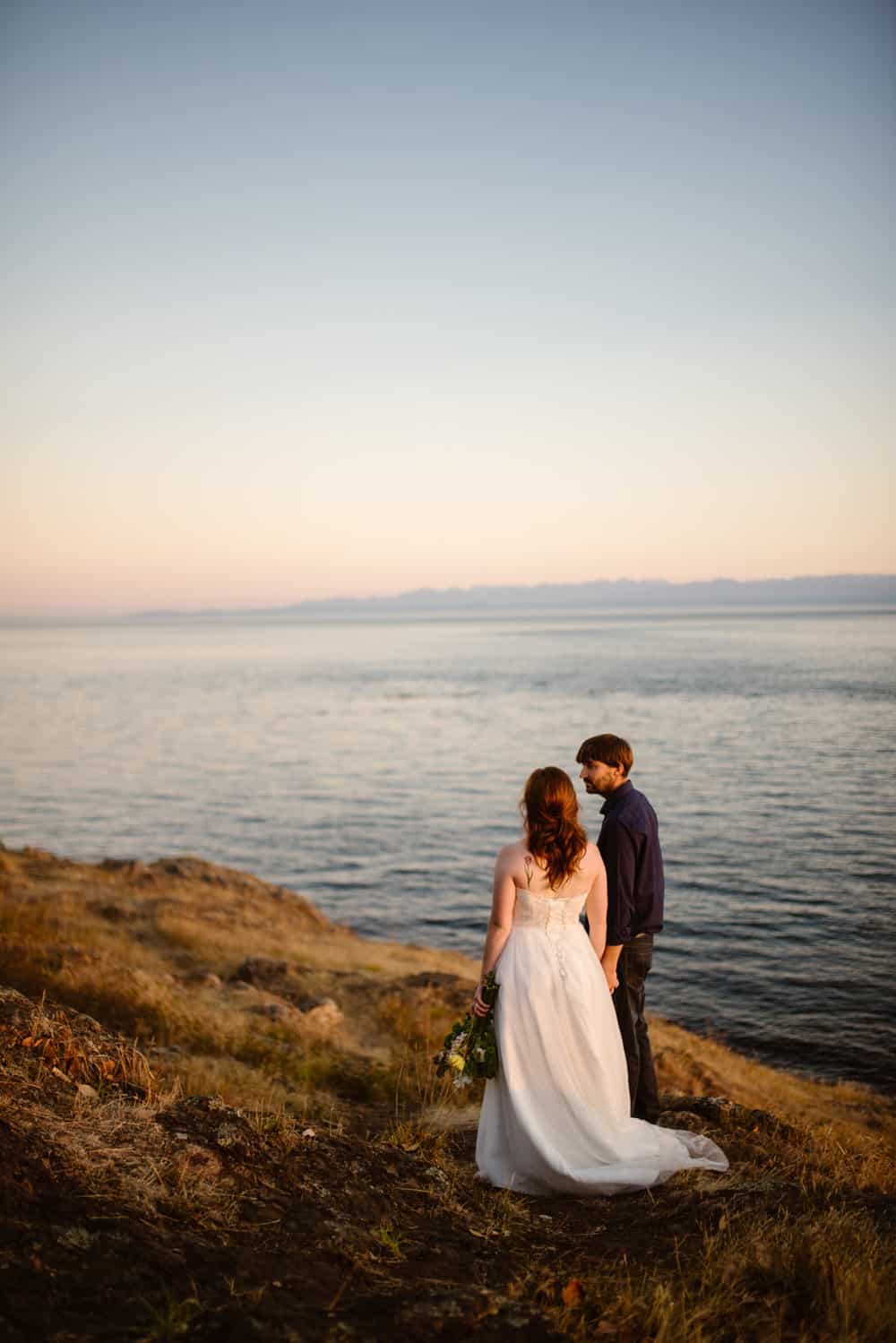 A man and woman take in the coastal sunset views.